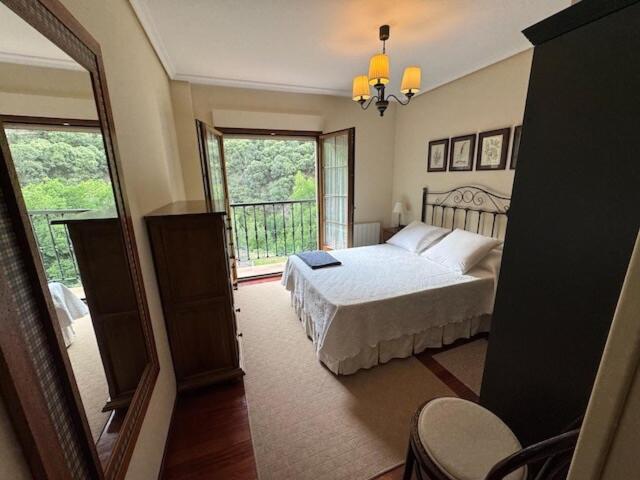 a bedroom with a bed and a large window at El Mirador de las Vegas in Potes