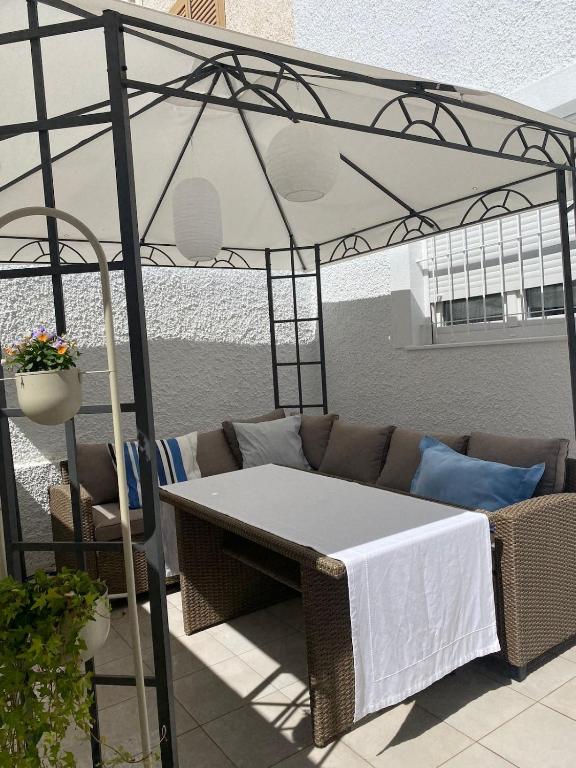 a couch under a canopy on a patio at Aparthaus Olive in Torrevieja