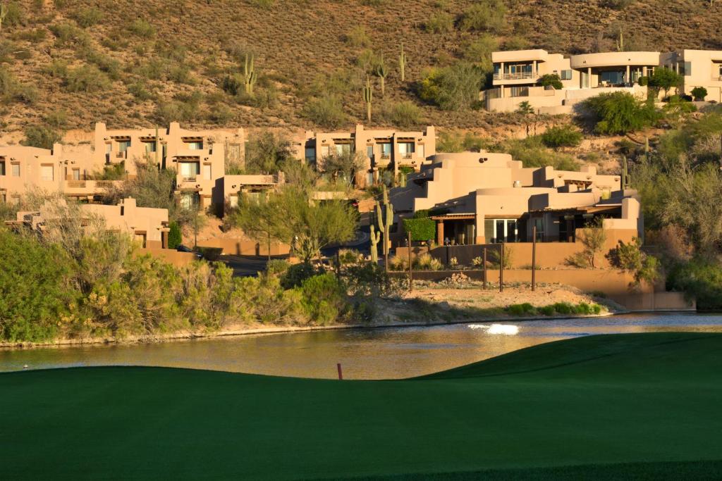 Blick auf einen Golfplatz mit einem Fluss und Häusern in der Unterkunft Inn at Eagle Mountain in Scottsdale