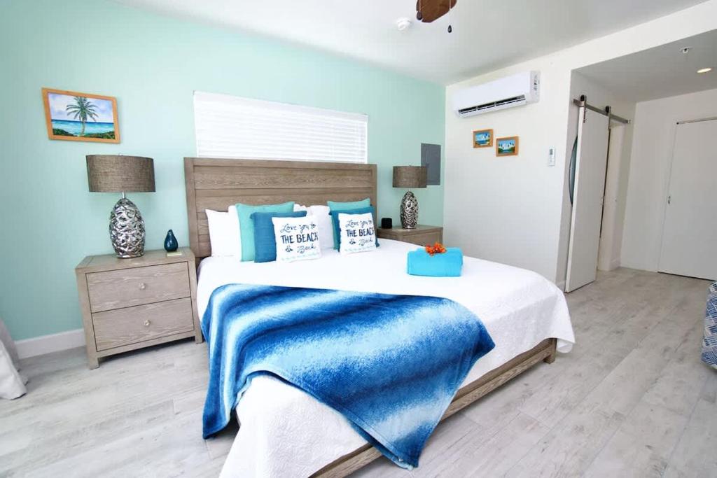 ein Schlafzimmer mit einem Bett mit einer blauen Decke darauf in der Unterkunft The Sunrise at Cottages in Sand Bluff