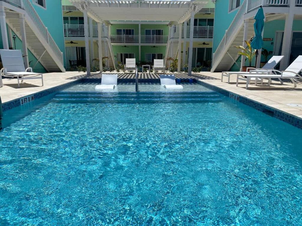 a swimming pool in a hotel with blue water at The Tropical Breeze Cottage in Sand Bluff