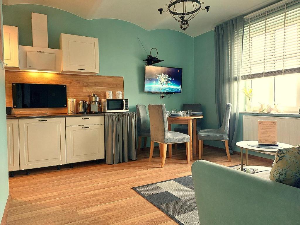 ein Wohnzimmer mit einer Küche und einem Tisch mit Stühlen in der Unterkunft Apartamenty Nova na Krakowskiej No 3 in Bielsko-Biała