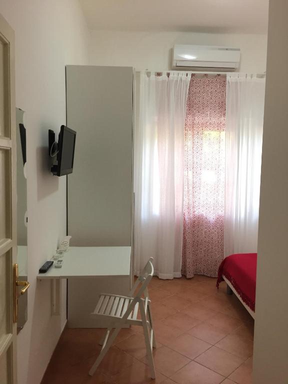 a room with a desk and a bed with a window at Villa Cenzina in Marina di Pisticci