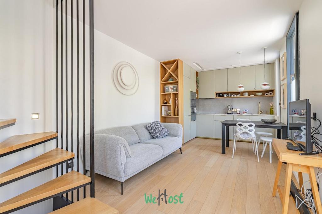 un salon avec un canapé et une cuisine dans l'établissement Raspail B - IDF - LB - Charming house at gates of Paris 3 people, à Bois-Colombes