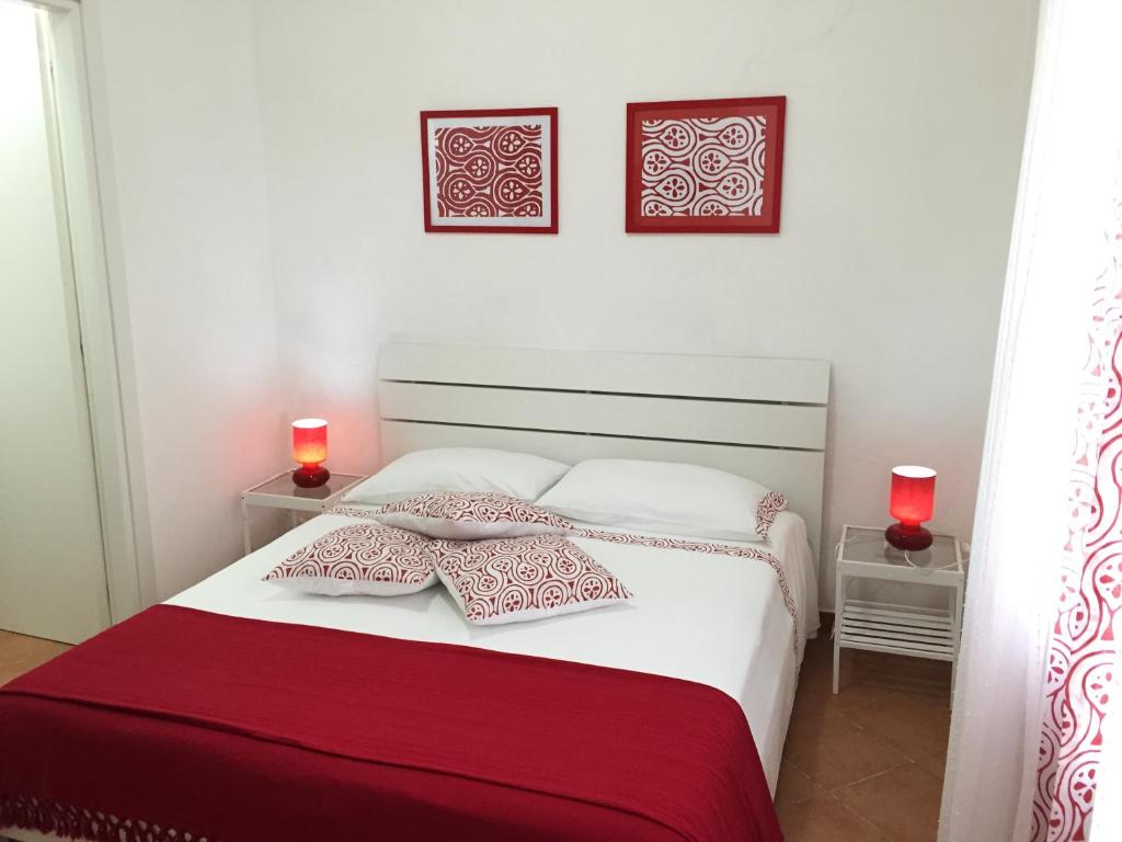 a bedroom with a white bed with two red candles at Villa Cenzina in Marina di Pisticci
