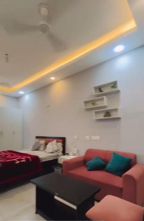 una sala de estar con un sofá y una cama en Northeye studio, en Noida