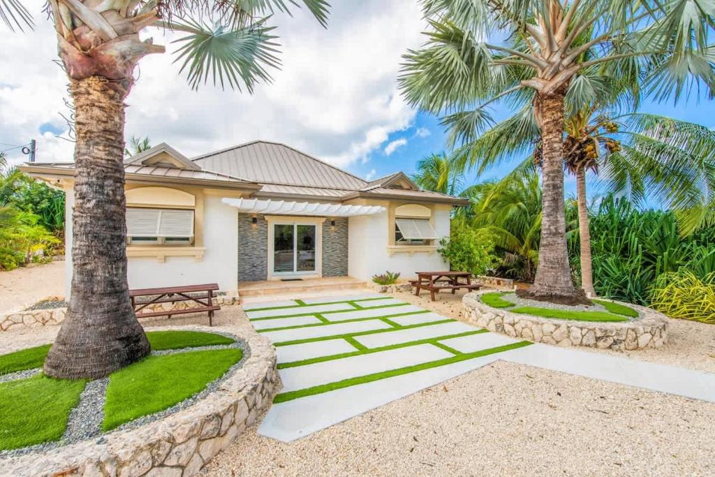 ein Haus mit Palmen davor in der Unterkunft The Mastic Sunnyhill Cottage in North Side