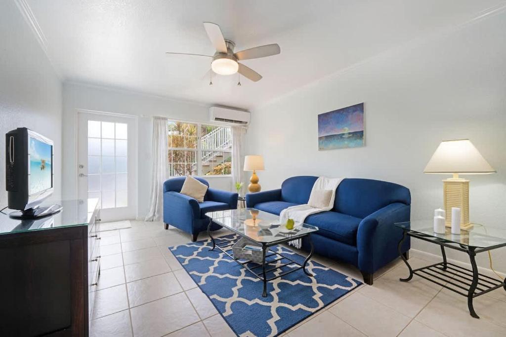 a living room with blue couches and a tv at Snug Harbour View Condo #2 in George Town