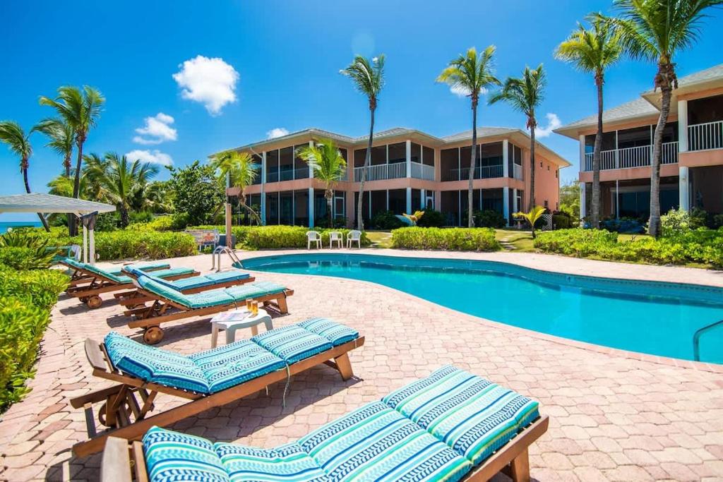 a resort pool with lounge chairs and a resort at Northern Lights #4 Condo in Old Man Bay