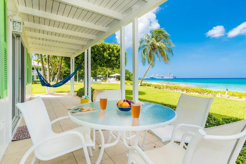 a table and chairs on a patio with the ocean at Cocoplum #1 Condo in George Town