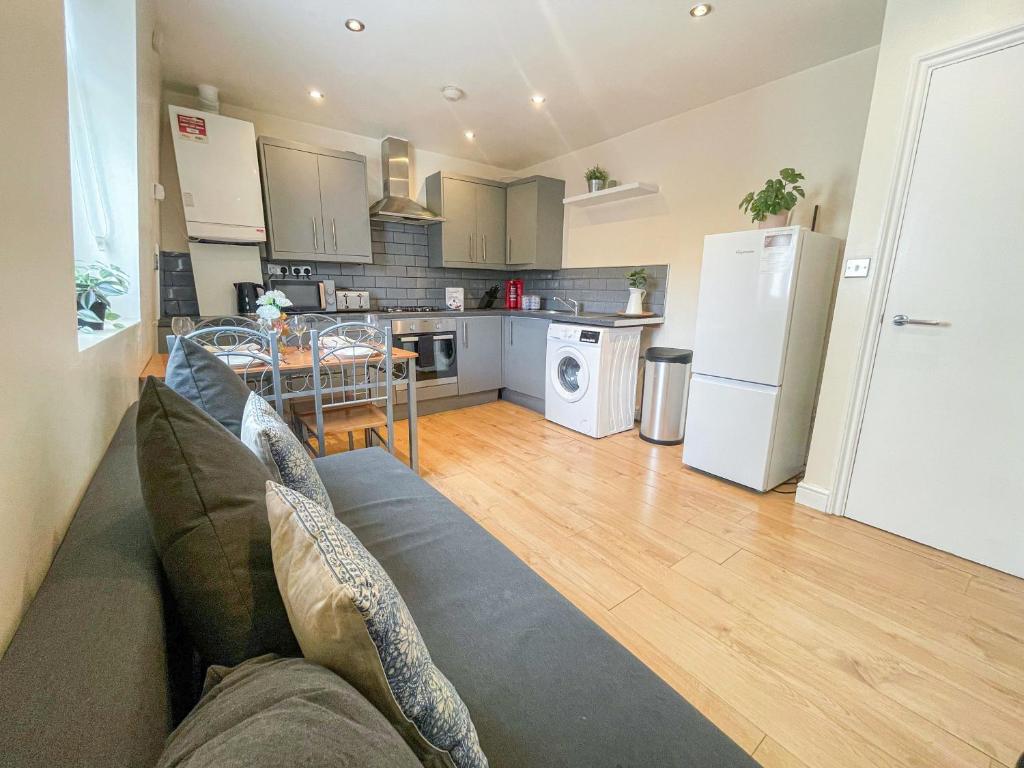 a living room with a couch and a kitchen at Bright 3-Bedroom Aldgate Flat with Free WIFI near Tower Hill, Brick Lane & Spitalfields in London