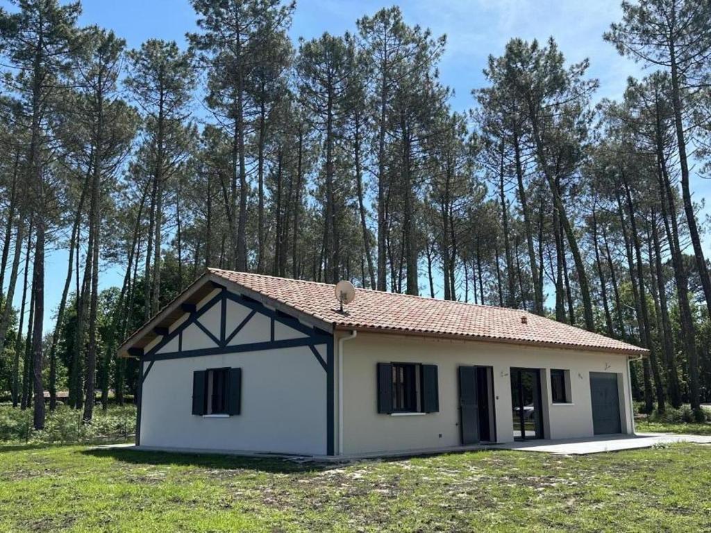 a small white house in a field with trees at les resiniers in Moliets-et-Maa