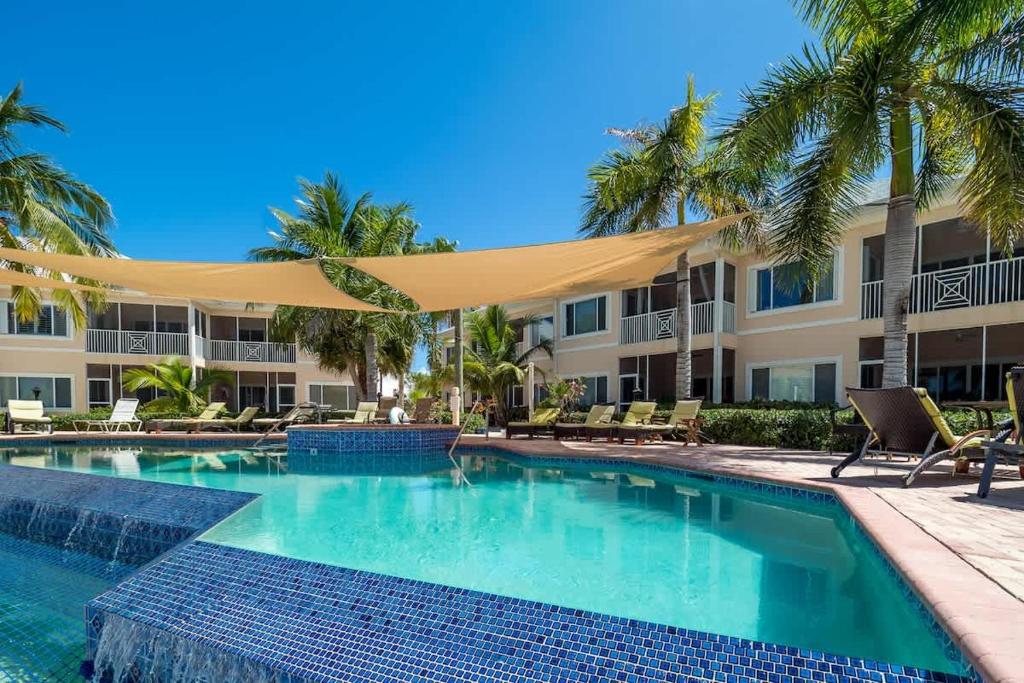 a swimming pool at a resort with palm trees at Colonial Kai Condo in Driftwood Village