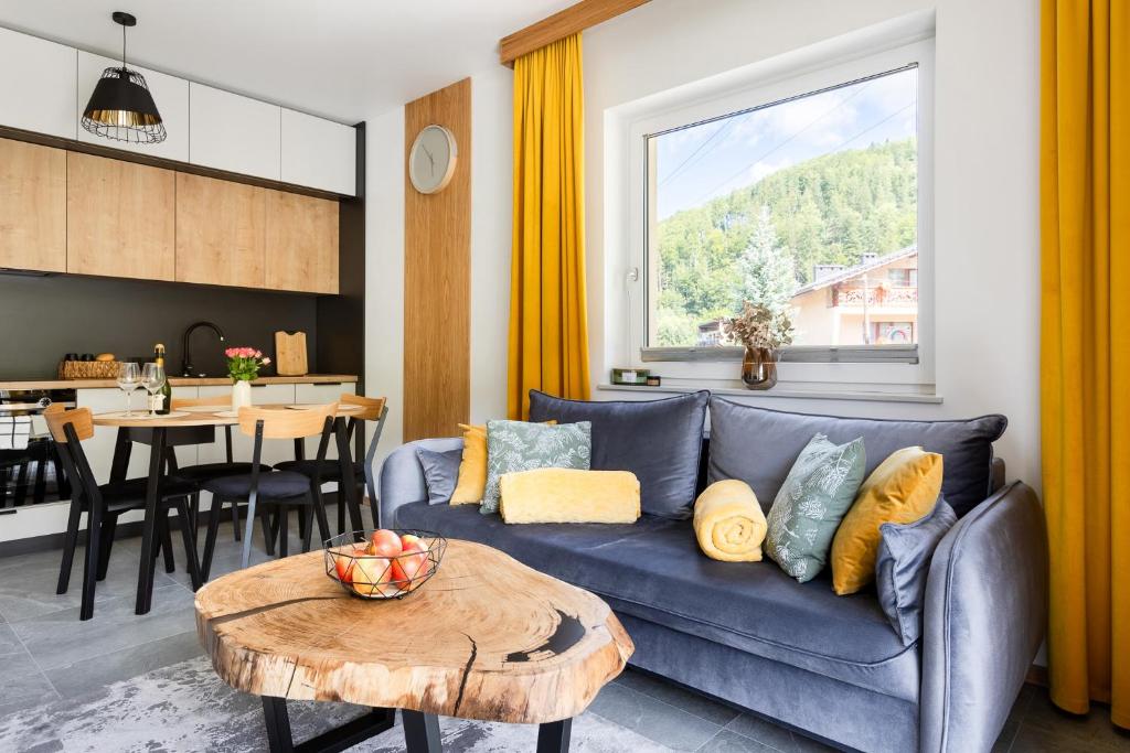 维斯瓦River Park Wisła - Golden Forest的客厅里有一张蓝色的沙发和一张桌子