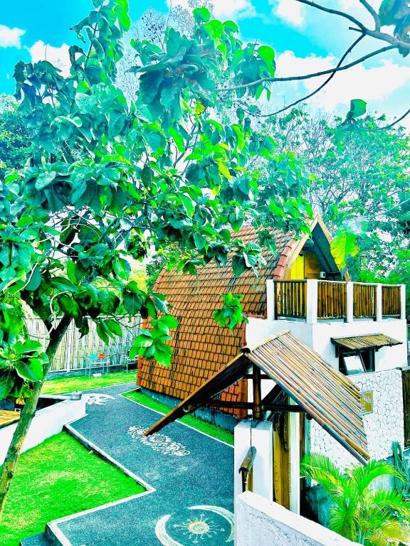 a view of a yard with a tree and a building at Rustic Loft Bungalow in Jimbaran in Jimbaran