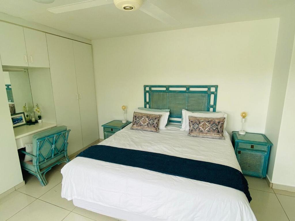 ein Schlafzimmer mit einem großen Bett mit zwei blauen Tischen in der Unterkunft Greek little Getaway - Paros Complex Apartment in Ballito