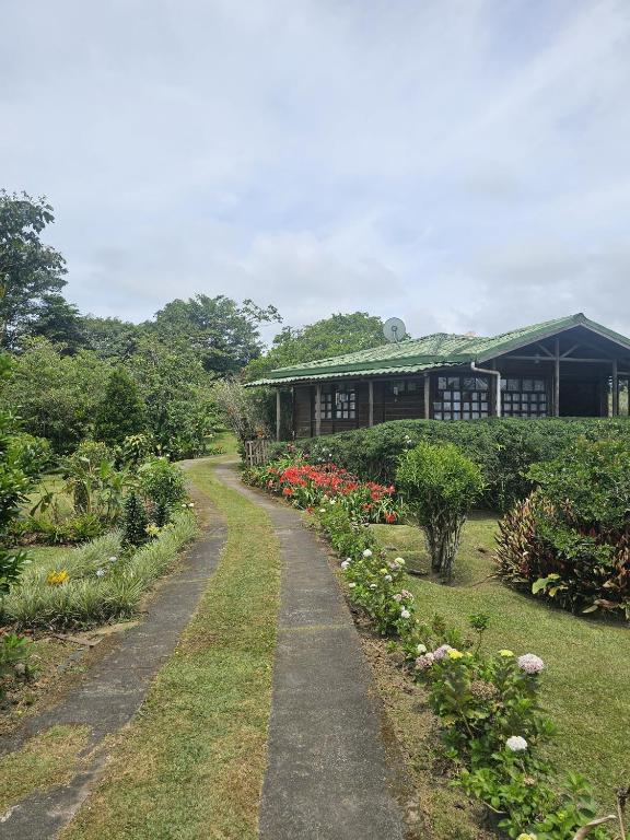 a path leading to a building with flowers at Mil Flores San Rafael Turrialba in Turrialba