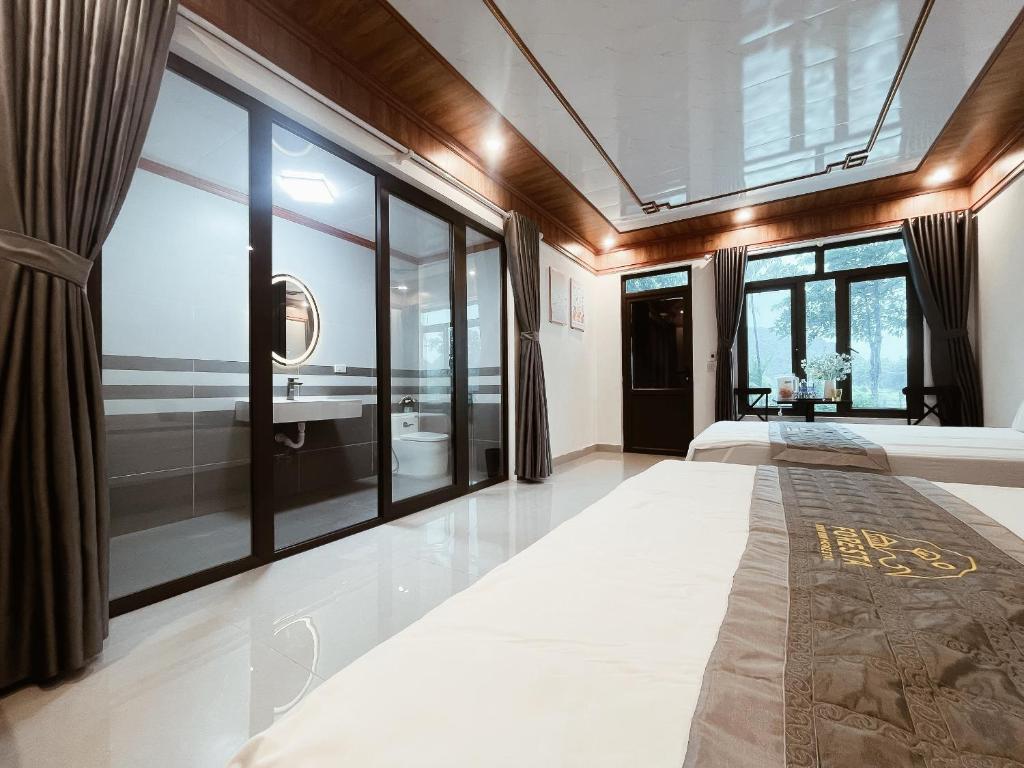 Un dormitorio con una cama y una ventana grande. en Foresta Trang An - Ninh Binh Homestay, en Ninh Binh