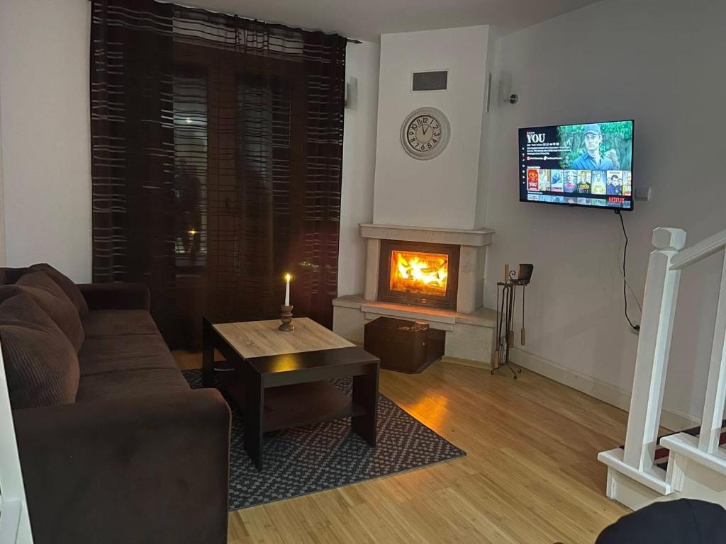 a living room with a couch and a fireplace at Pamporovo Duplex Apartment Fireplace 2 Bathrooms Shuttle in Smolyan