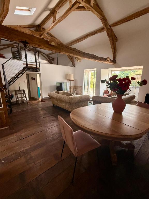 a living room with a table and a couch at Gîte Le Patio Bleu in Saint-Romain
