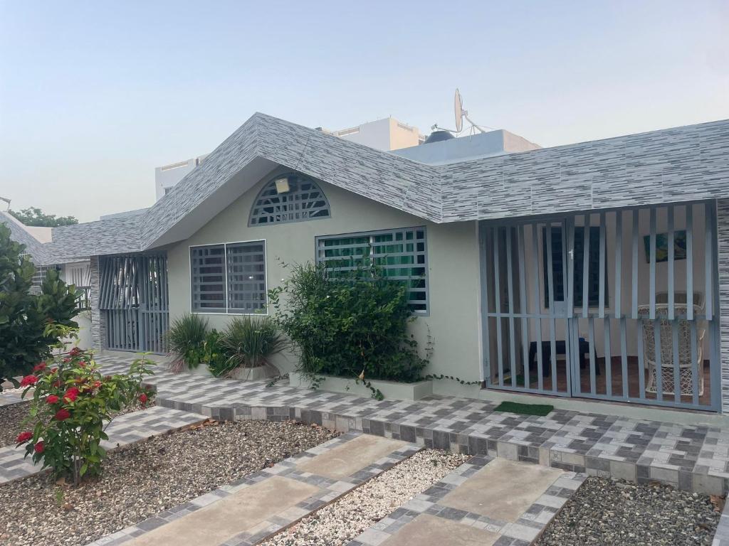 a small white house with a porch and stairs at res Montesino in San Felipe de Puerto Plata