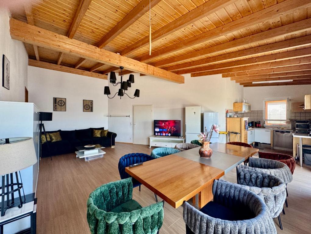 a living room with a wooden table and chairs at Ferienhaus Event Haus EMG Hockenheim für Familien und Gruppen bis 22 Personen mit Partyraum in Hockenheim