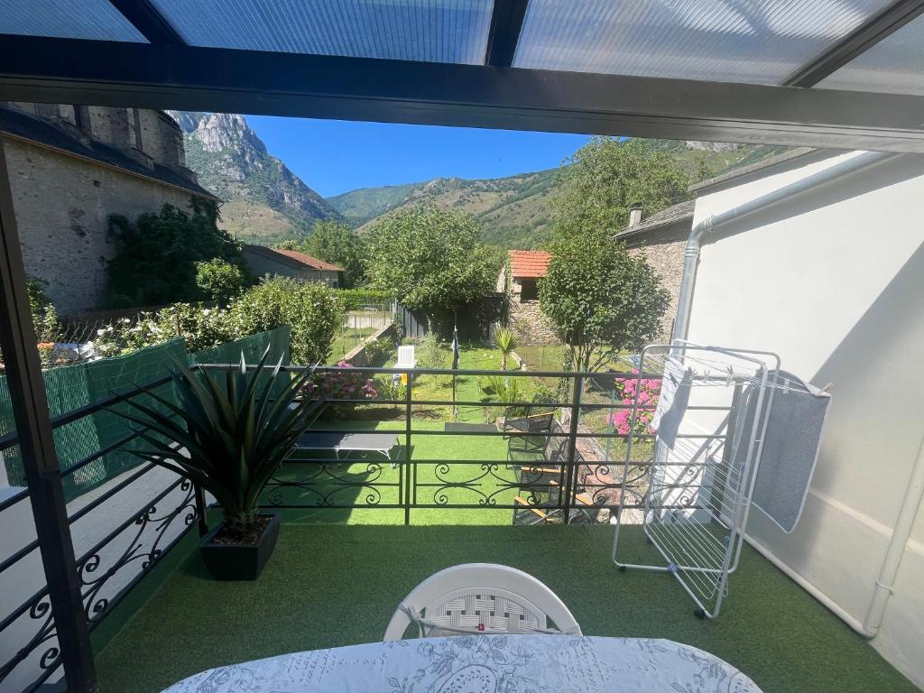 a balcony with a table and a view of a garden at Maison du plateau de beille in Les Cabannes