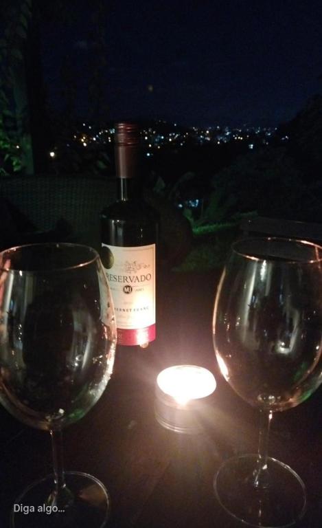 two wine glasses sitting on a table with a bottle of wine at casa para Oktoberfest in Blumenau
