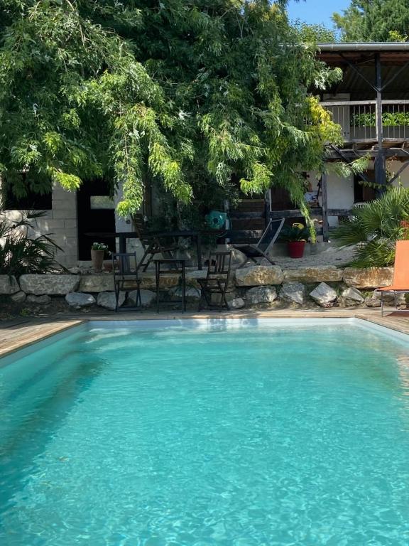 a large pool with blue water in a yard at Dépendance atypique 2chbres parc piscine in Villebrumier