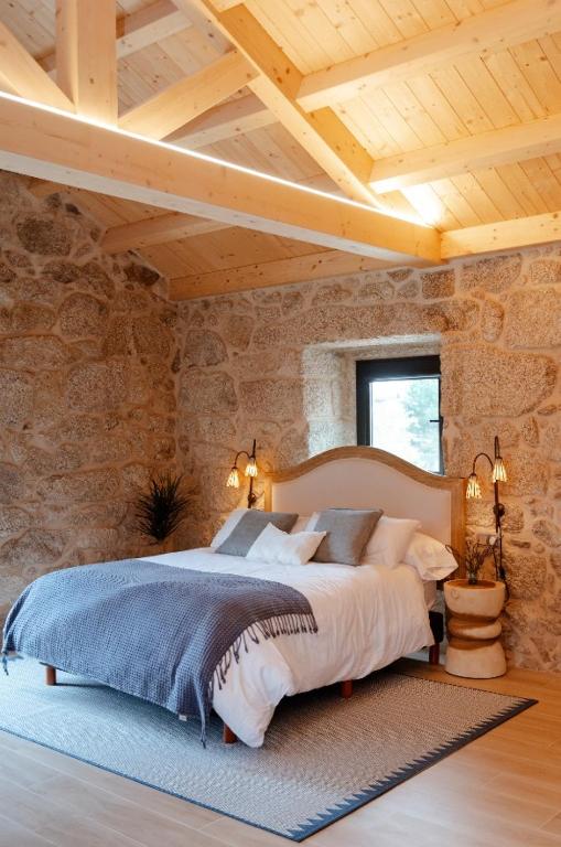 a bedroom with a large bed in a stone wall at Casa Chare in Moaña
