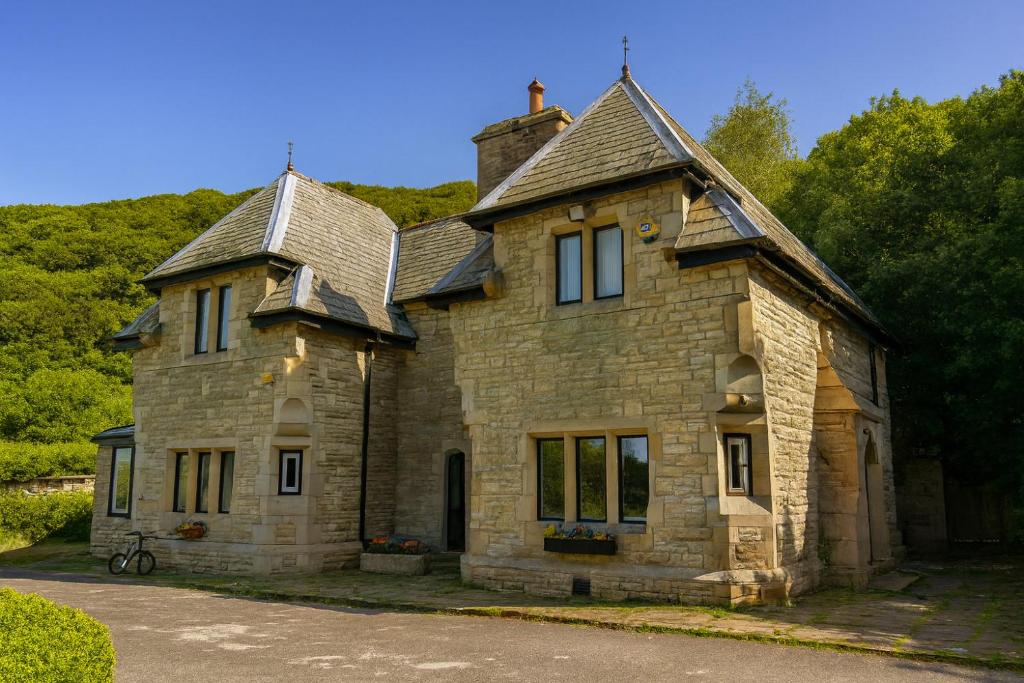 an old stone house sitting on the side of a road at 4 Bed Retreat-Sleeps 7-Parking-Garden-Lake Views in Bolton