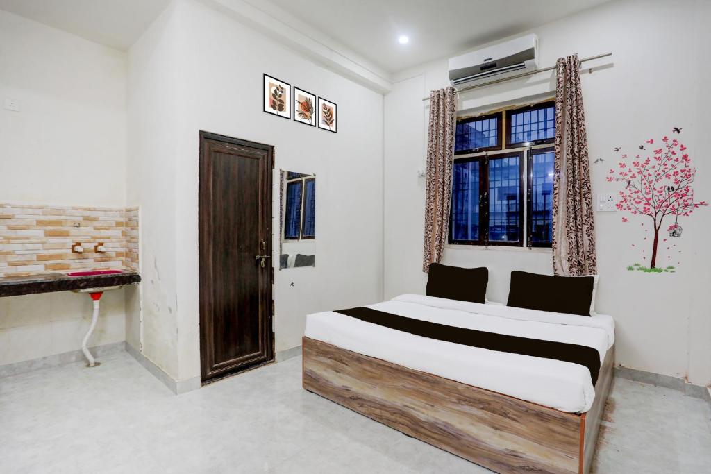 a bedroom with a bed and a window at Hotel O Kashi Home in Kakarmatha