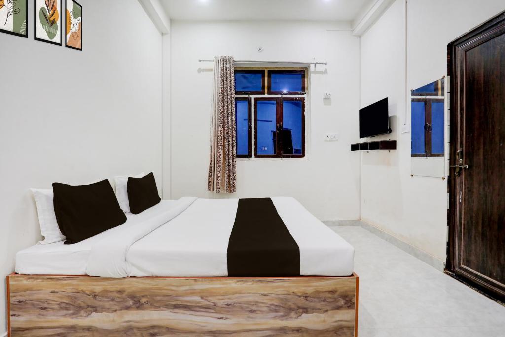 a bedroom with a large bed and a window at Hotel O Kashi Home in Kakarmatha