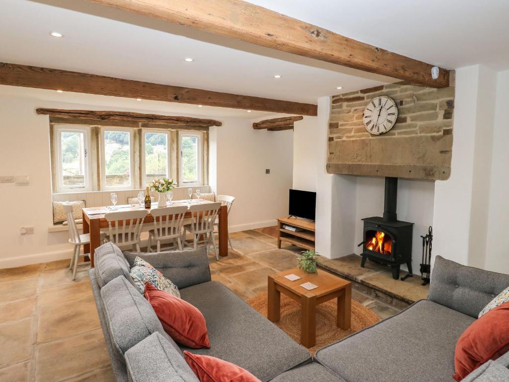 a living room with a couch and a fireplace at Hill Top Cottage in Holmfirth