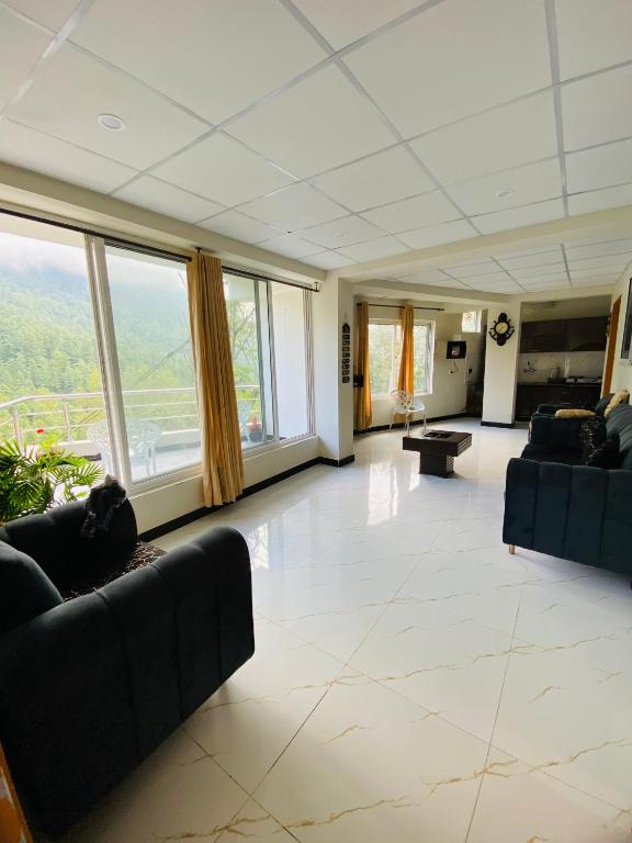 a large living room with couches and large windows at Mount Vista Resort in Murree