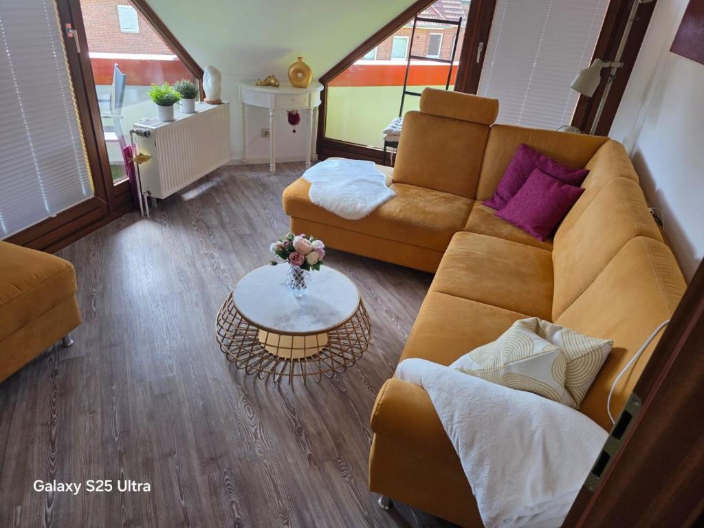 a living room with a couch and a table at PEMATRA FeWo Nordlicht in Travemünde