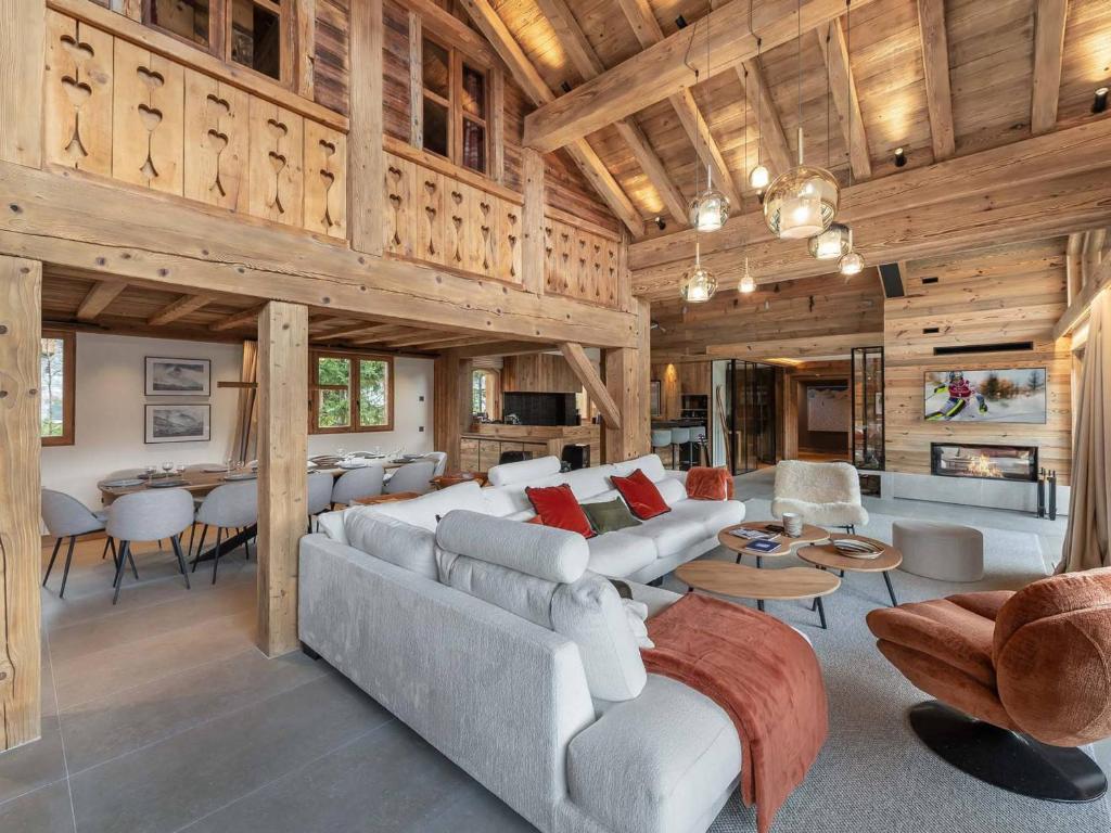 una sala de estar con un sofá y una mesa en Chalet 5⭐ à Méribel avec Spa, Salle de Sport, Proche des Pistes et Commerces - FR-1-566-62, en Les Allues