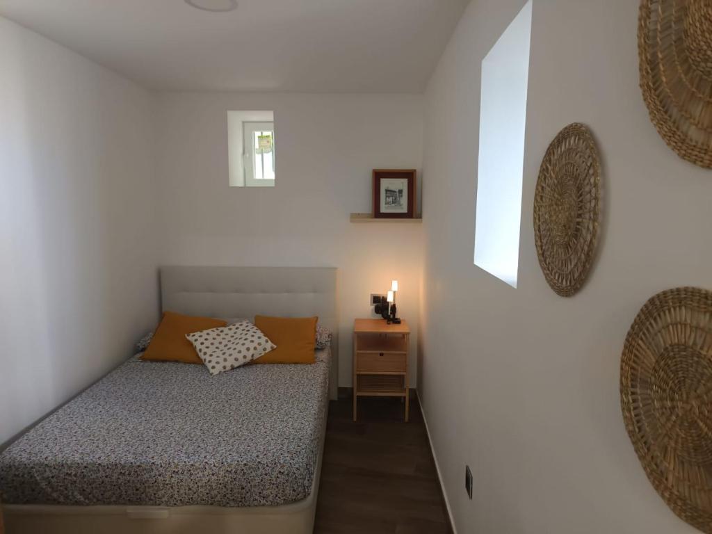 a small bedroom with a bed and a night stand at El Apartamento de Hervás in Hervás