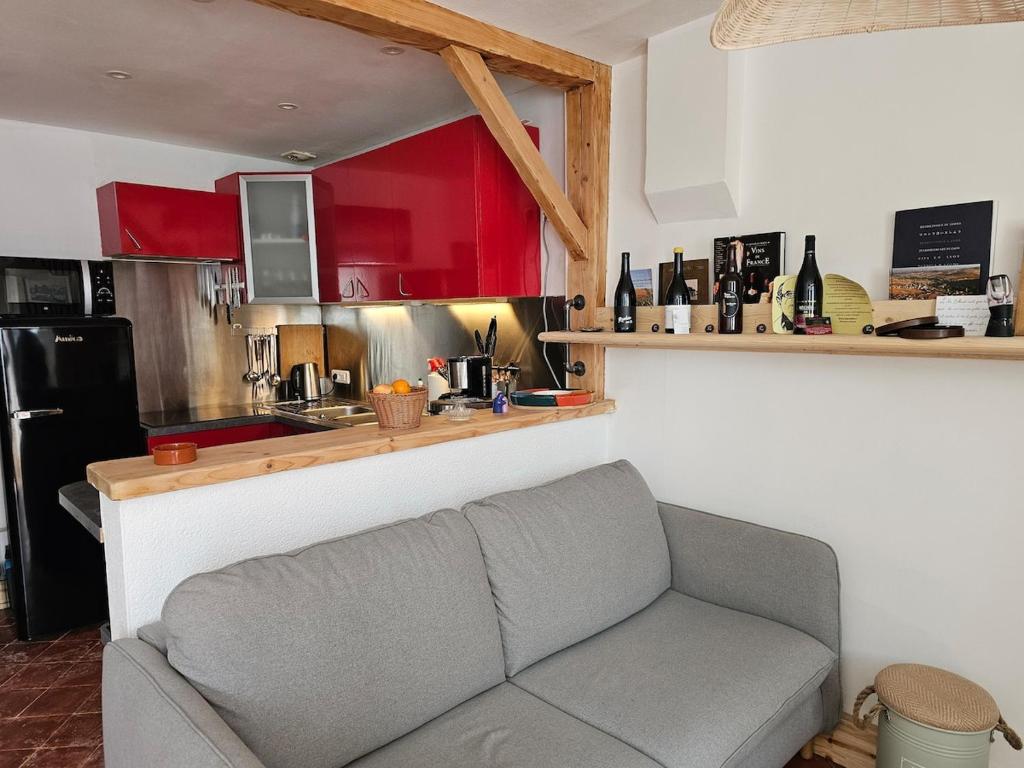 a living room with a couch and a kitchen at La maison du père Bellessort in Régnié