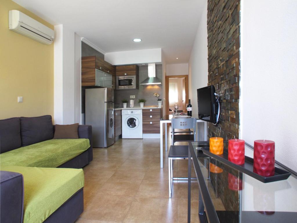 sala de estar con sofá y cocina en Apartamentos Amanecer JC1, en Murcia