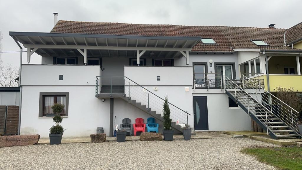 a white house with a staircase in front of it at Gites Bretzel Cigogne ET Manala in Munwiller