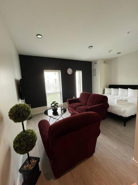 a living room with a bed and couches in a room at Red Velvet Studio in Des Moines