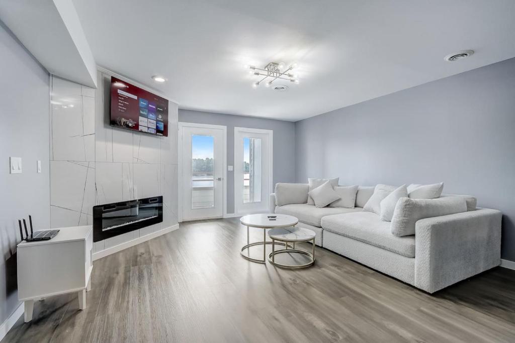 a white living room with a couch and a tv at Dells Lakefront Luxe Haven in Wisconsin Dells