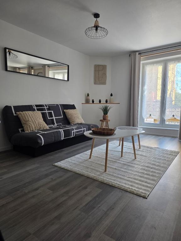 a living room with a couch and a table at appartement Sedan, France in Sedan