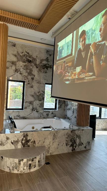 a large projection screen in a bathroom with a tub at Hotel oasis Sevilla Valle in Sevilla