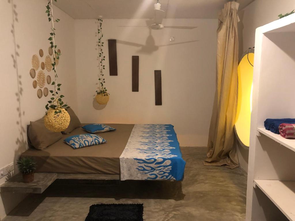 a bedroom with a bed with blue pillows on it at Dana's Villa in Ahangama