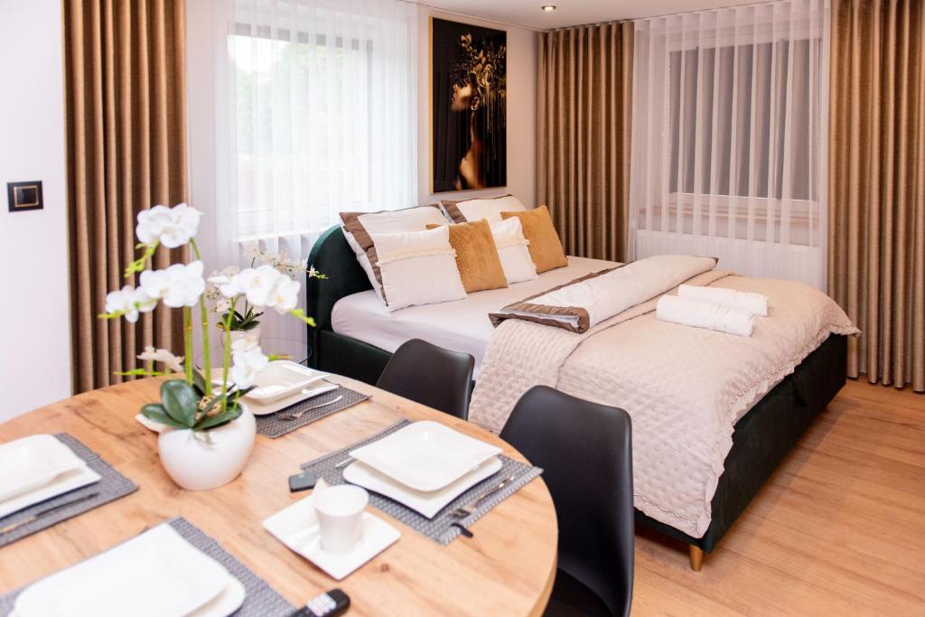 a room with two beds and a table and a dining room at Apartamenty nad Starynką in Głuchołazy