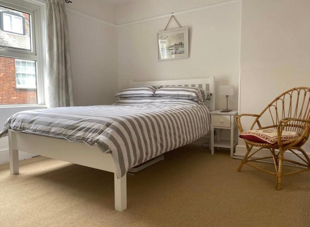 a bedroom with a bed and a chair and a window at Bimble Cottage-2 beds-Gorgeous Sunny Garden in Topsham