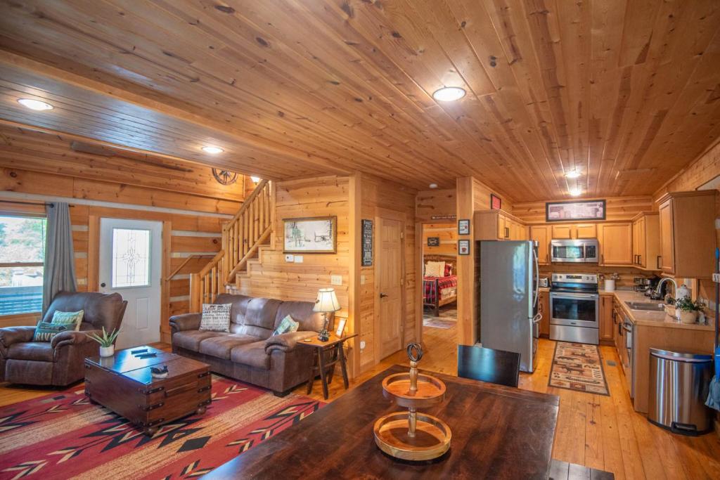 a living room with a couch and a kitchen in a cabin at Adventure Cabin! Fire Pit, State Park, Fishing, Mtn Views, Hot Tub, WiFi in Jefferson