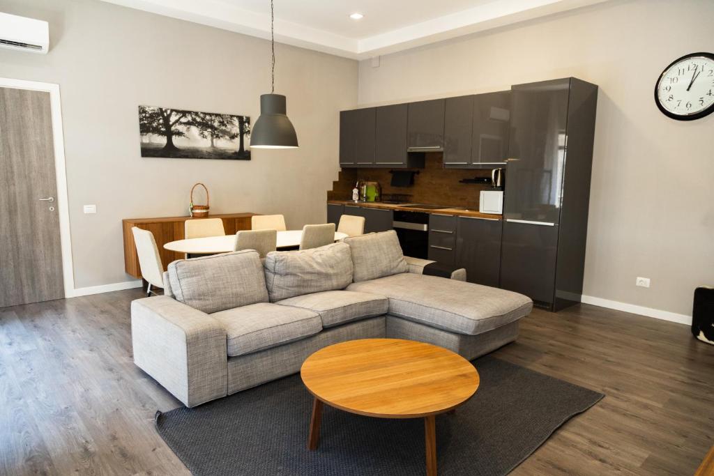 a living room with a couch and a table and a kitchen at Miracle Apartment Hotel in Baku